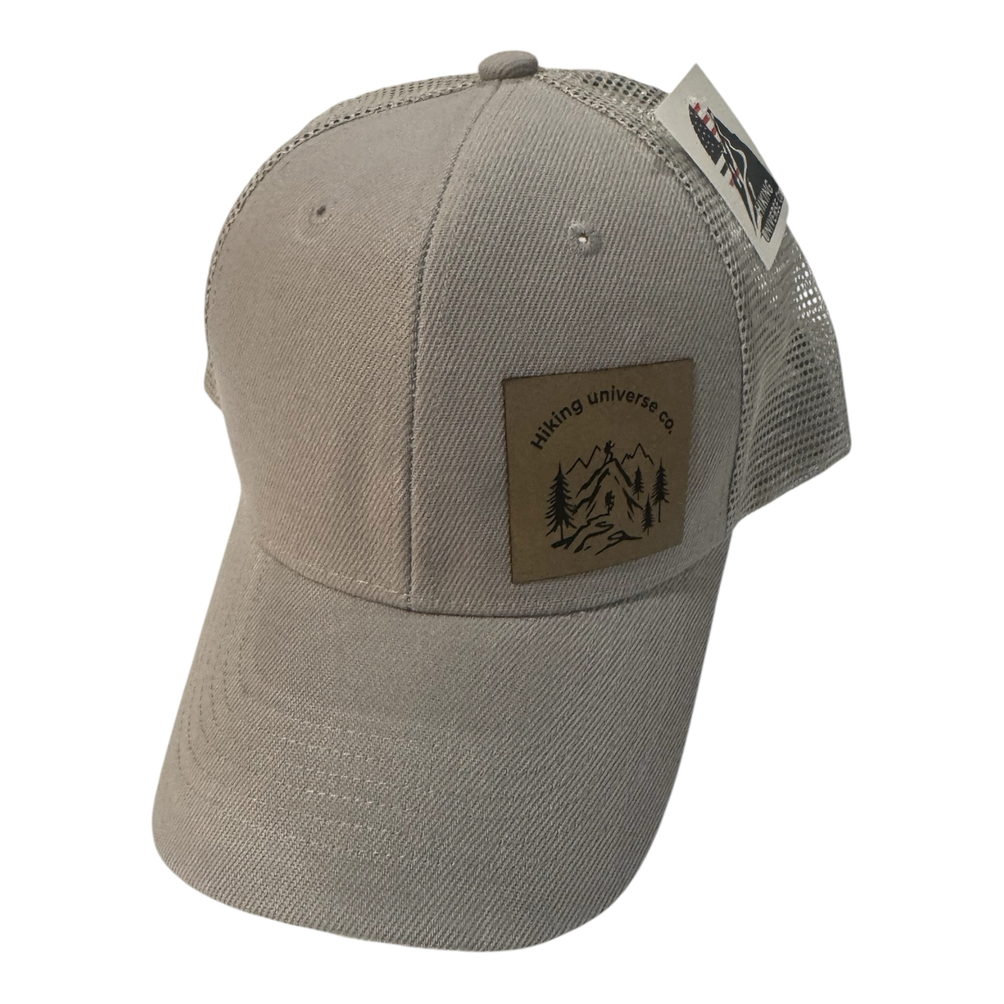 Hiking Universe Co. beige cotton twill trucker hat with mesh back and faux leather patch featuring mountain landscape.