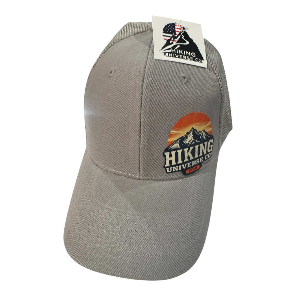 Hiking Universe Co. grey cotton blend trucker hat with mesh back and embroidered mountain sunset patch.